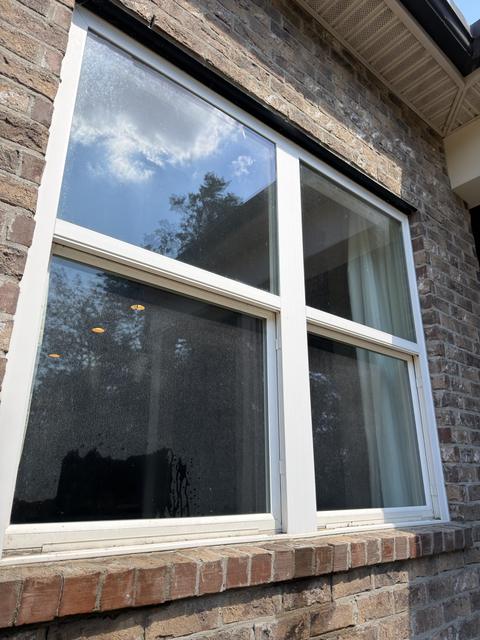 Exterior window before cleaning, glass covered in water spots and film