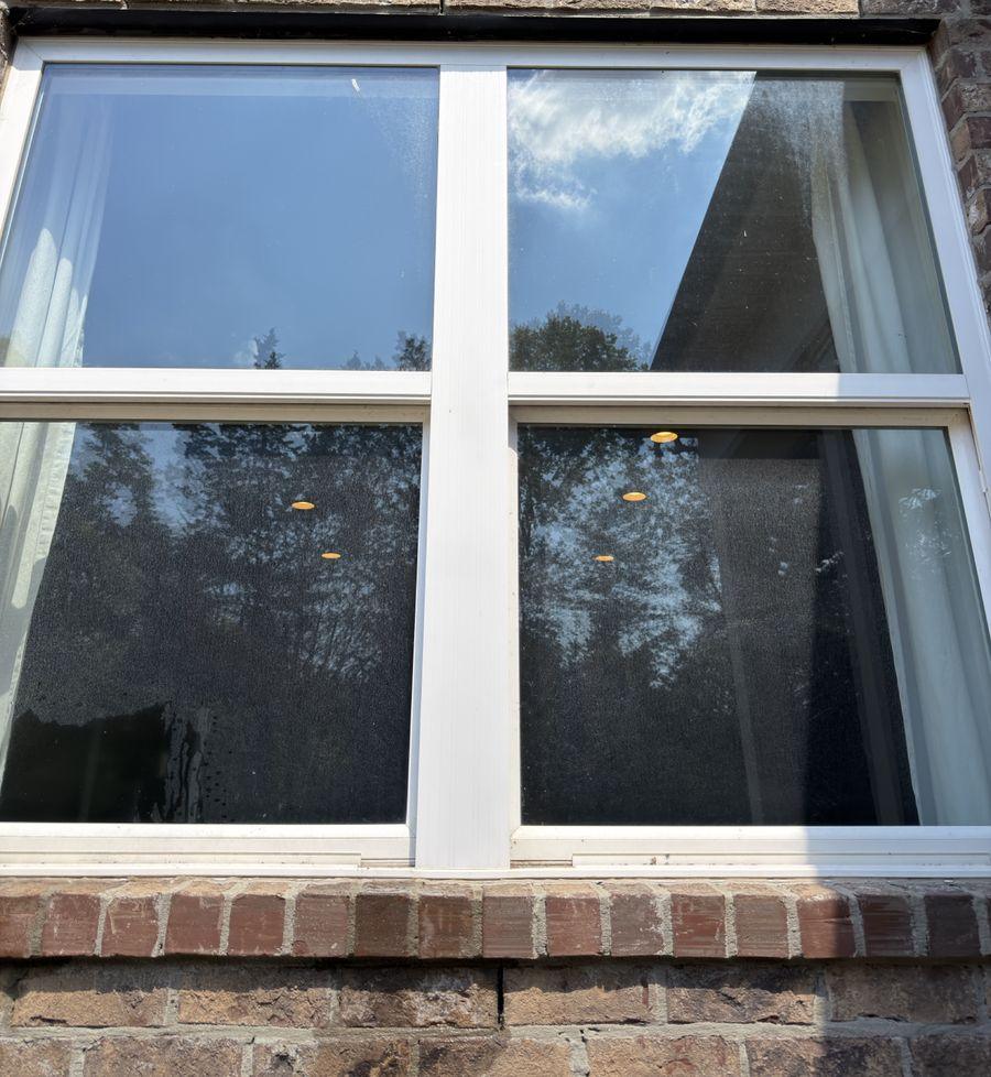 Before: the same window with spotted, hazy glass